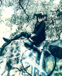 a girl sitting on top of a rock with graffiti on it