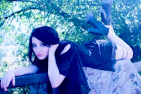 a young woman laying on a rock in the woods