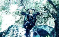 a woman sitting on a rock with her arms outstretched