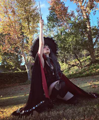 a woman dressed as a witch holding a wand