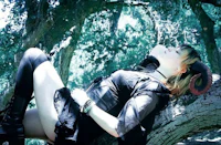 a woman laying on a tree in a black outfit