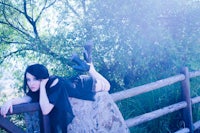 a woman posing on a wooden fence