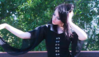a woman in a black dress posing on a railing